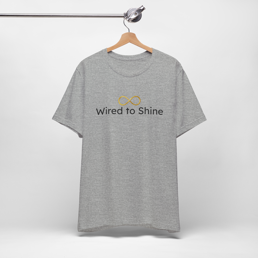 Grey shirt with golden infinity symbol. Has wired to shine text. Hanging on a hanger.