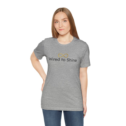 Woman wearing a gray t-shirt with 'Wired to Shine' text on a white background