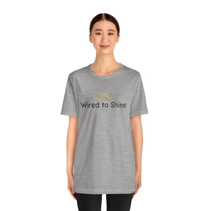 Person wearing a gray t-shirt with 'Wired to Shine' text and logo on a white background