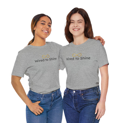 Two women wearing gray 'Wired to Shine' t-shirts on a white background