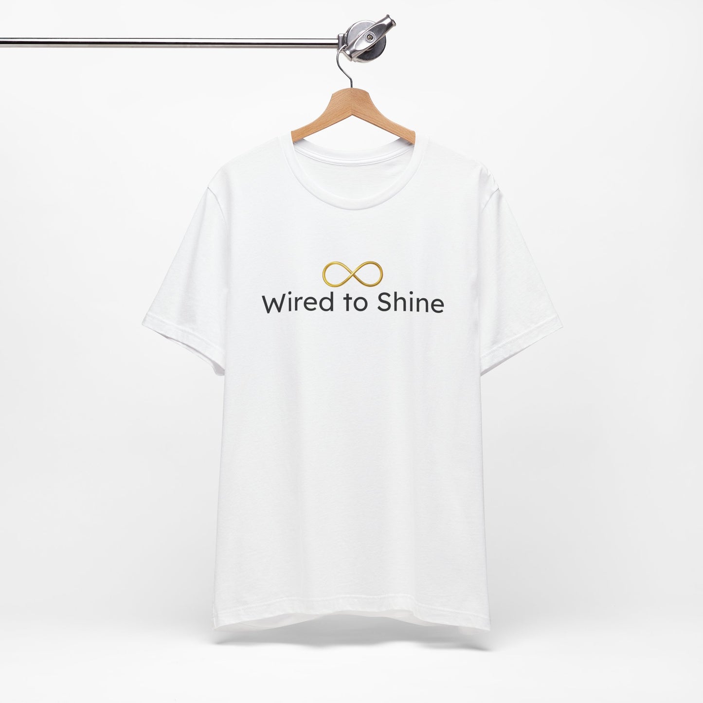 White t-shirt with 'Wired to Shine' text on a hanger against a white background