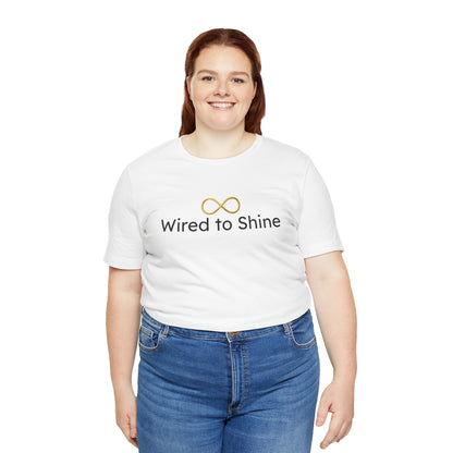 Person wearing a white t-shirt with 'Wired to Shine' text and blue jeans on a white background